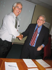 Mike Lawson and Ralph Braibanti shake hands while signing the Joint Delegation Statement