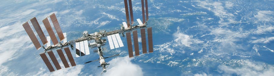 The International Space Station flying over a cloudy blue Earth