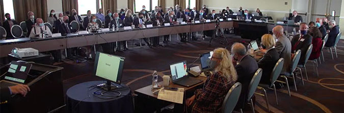 Board members seated around long table in conference room