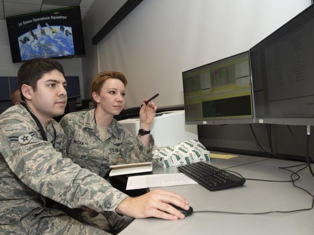 Operators sitting at a desk working at a computer.