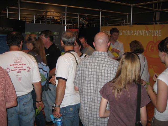 A roomful of people standing very close to each other.
