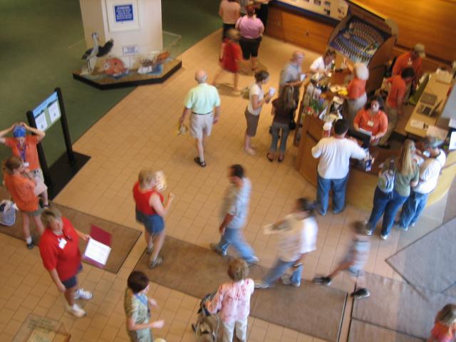 A bird's eye view of the lobby/exhibit with people walking around.