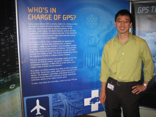 Jason Kim stands in front of a large panel labeled Who's In Charge of GPS.